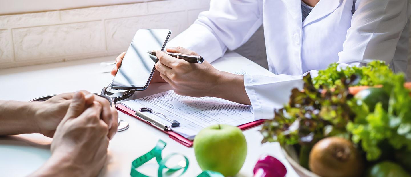 A dietitian showing a client information on a phone.